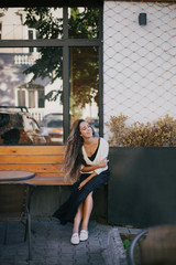 Young beautiful happy woman with long curly hair having free time outdoors