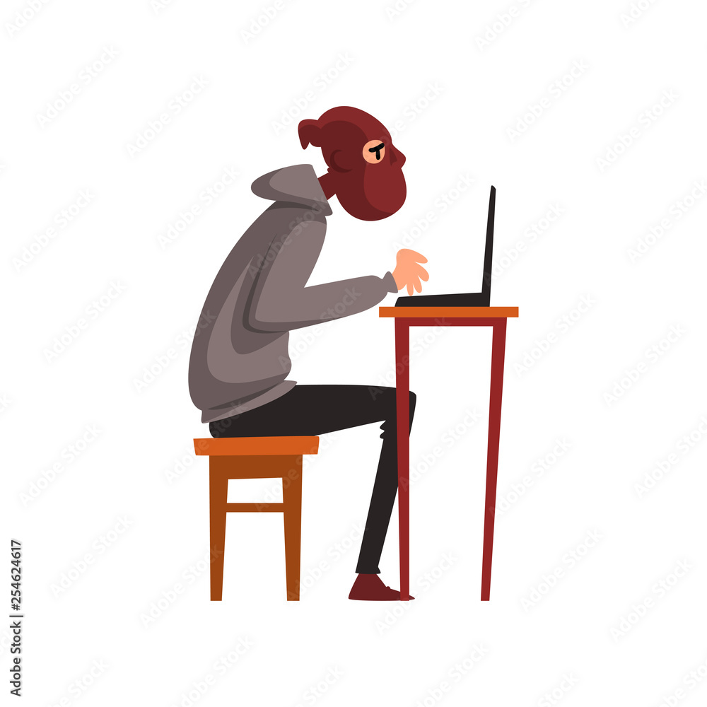 Poster hacker in disguise sitting at desktop and working on laptop, internet crime, computer security techn