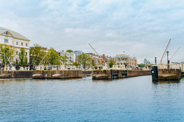 Fototapeta na wymiar Amsterdam, Netherlands September 5, 2017: Reflection of trees and houses in still water of Amstel river, Amsterdam, Netherlands.