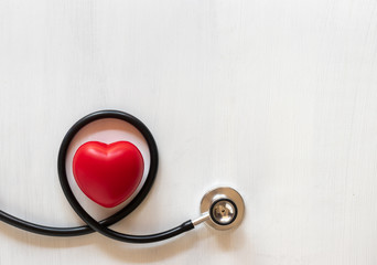 Stethoscope and heart on wooden background. Health care concept