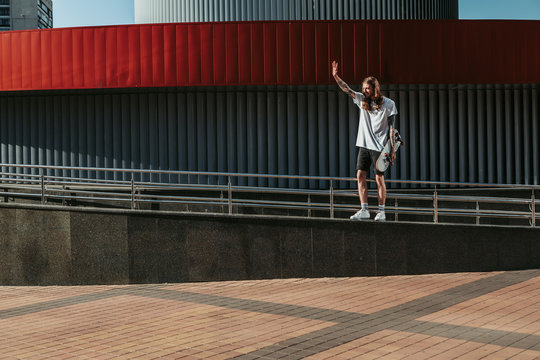 Full length of a delighted skateboarded welcoming passers by