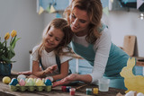Mom and daughter being satisfied of dyeing eggs