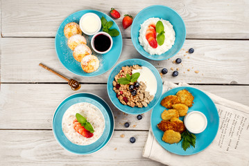Different types of breakfast shot on wooden background