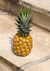 Ripe, fresh pineapple isolated on stone stairs