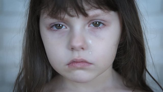 Portrait of a crying child. A cute little girl is crying. Child abuse concept.