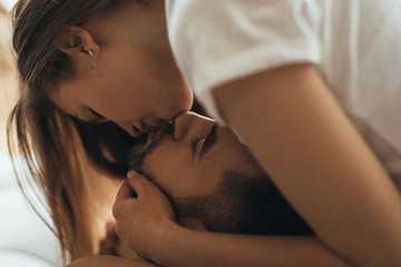 Close-up of young romantic couple is kissing and enjoying the company of each other at home