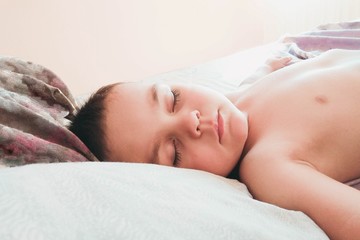 Fototapeta na wymiar little boy sleeps in the afternoon at home