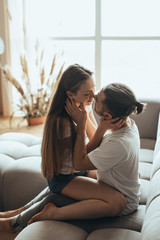 Fototapeta premium Young romantic couple is kissing and enjoying the company of each other at home