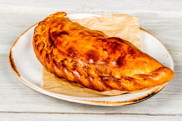 Italian calzone on a white plate close-up shot