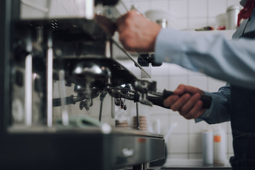 Man preparing professional coffee machine in cafe