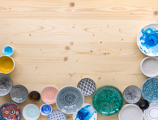 different kinds of modern colourful crockery in different designs on light wood background