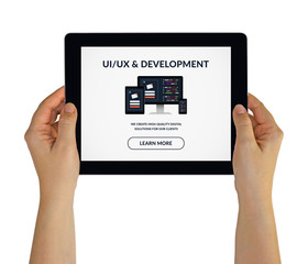 Hands holding tablet with UI/UX design and development concept on screen