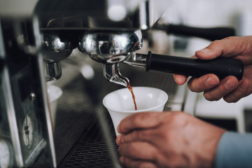 Fototapeta na wymiar Man making espresso with professional coffee machine