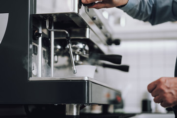 Man preparing professional coffee machine for work