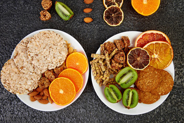 Healthy snacks -  variety oat granola bar,  rice crips, almond,  kiwi, dried orange