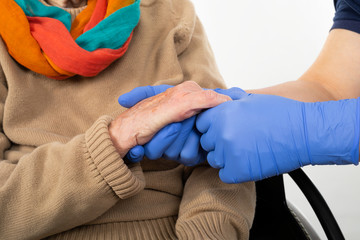 Nurse holding disabled woman's hands