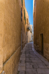 Narrow street in the town of Mdina, Malta in sunny day