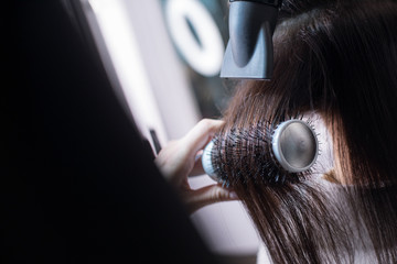 Hairdresser is making fashionable hairstyle for client in barber shop