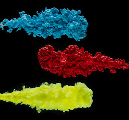 Coloured acrylic ink mixing in water on black