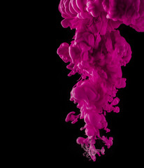 Coloured acrylic ink mixing in water on black
