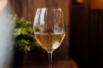 Glass of white wine on wooden table
