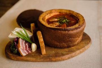 Traditional Ukrainian and Russian borscht with pork lard and garlic on bread plate. Red beet root...