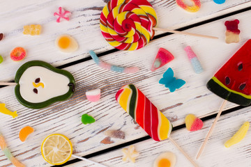Colored candies, sweets and lollipops. Mixed candies on vintage wooden background.
