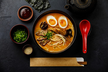 Ramen asian noodle in broth with Beef tongue meat, mushroom and Ajitama pickled egg in bowl on dark...