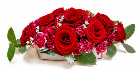 Floral arrangement of red roses and carnations for table decoration (wedding, restaurant) on a white background.