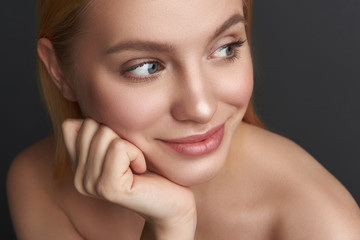 Naklejka premium Portrait of pleased woman with natural makeup looking away