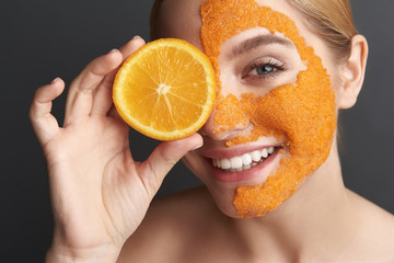 Close up of woman with orange peel mask feeling happy