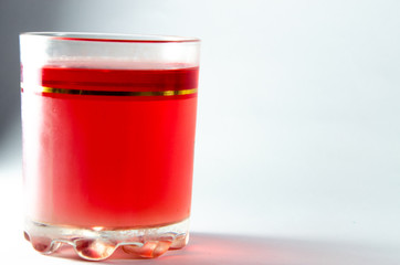 Bright red jelly in a glass on a light and dark background