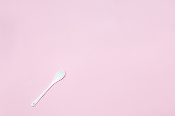 Ceramic white spoon on a pink background copy space