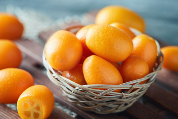 Kumquats or cumquats (Citrus japonica) on wooden background