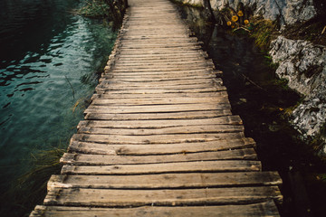 Fototapeta premium Wooden pathway in Plitvice National Park, Croatia, Europe. Popular nature tourist attraction Plitvice lakes.