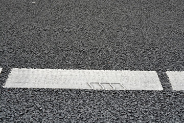 Fototapeta premium Asphalt road with marking stripes with tracking marks of tires