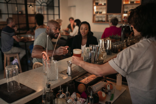 Young couple having drinks at a bar in the evening