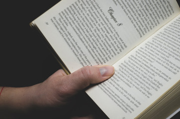 Men's hand holds an open book ready for reading