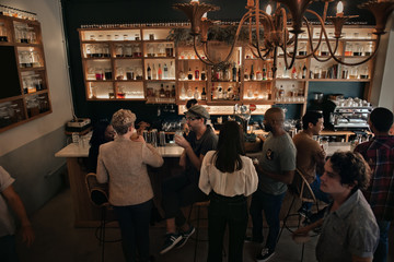 Diverse people enjoying drinks at a pub in the evening