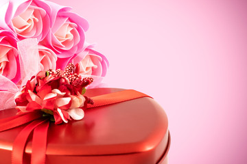 Gift box and bouquet of roses for holiday on wooden background.