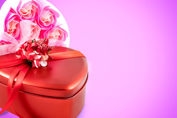 Gift box and bouquet of roses for holiday on wooden background.