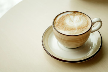fresh cappuccino in a Cup on the table, a Cup of hot coffee, coffee with a foam pattern