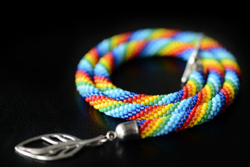 Bead crochet necklace rainbow colors on a dark background close up