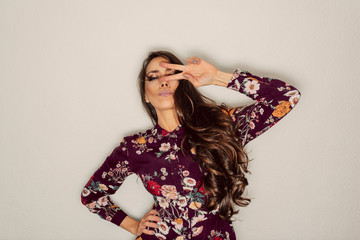 beautiful  woman showing peace sign over eye with cool gesture