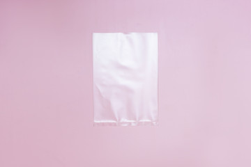 one cellophane bag pack. White bag package template in centre pink background copy space flatlay