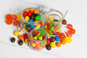 Bottles with sweet candies on table