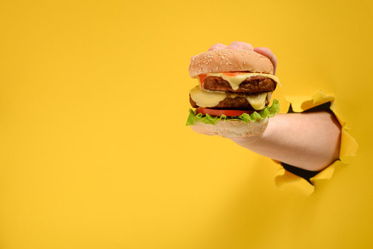Hand taking a big burger