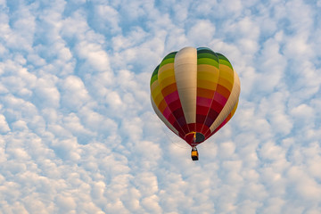 Colorful hot air balloons floating above the lake with blue sky in Singha Park ,Chiang Rai, Thailand.