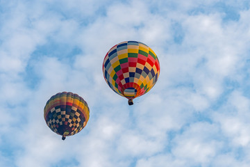 Colorful hot air balloons floating above the lake with blue sky in Singha Park ,Chiang Rai, Thailand.