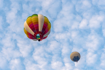 Fototapeta premium Colorful hot air balloons floating above the lake with blue sky in Singha Park ,Chiang Rai, Thailand.